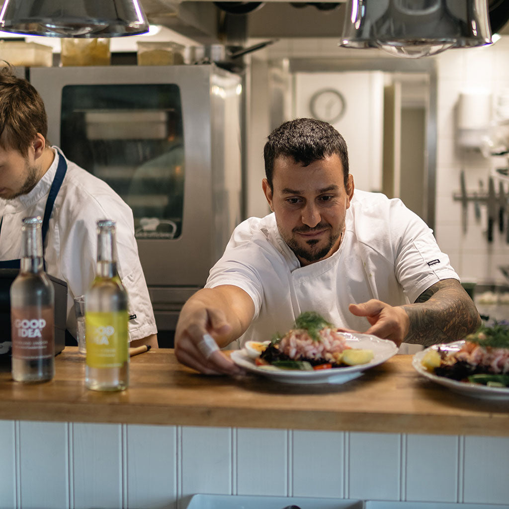 Kock på Skillinge Hamnkrog serverar räkmacka med Good Idea sparkling lingon och Good Idea sparkling cirtron på flaska