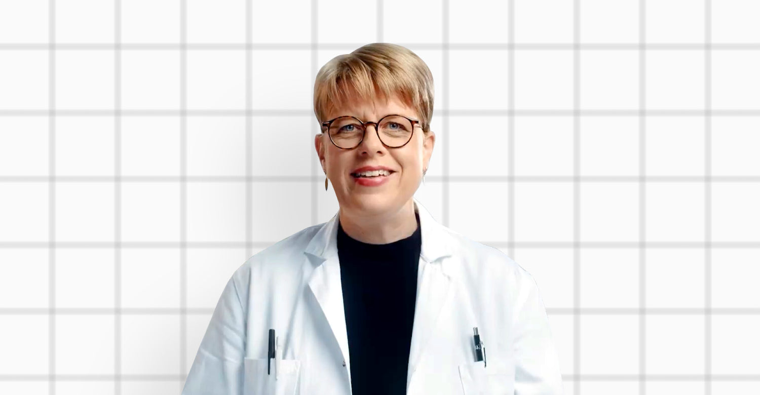 Doktor Elin Östman, Cheif Scientific Officer på Good Idea, i labbrock framför en rutad bakgrund.